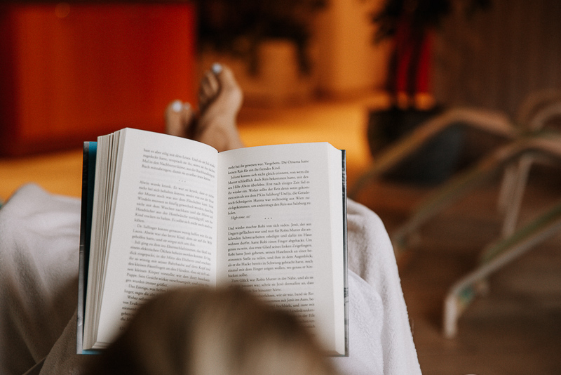 Frau im Bademantel liest ein Buch